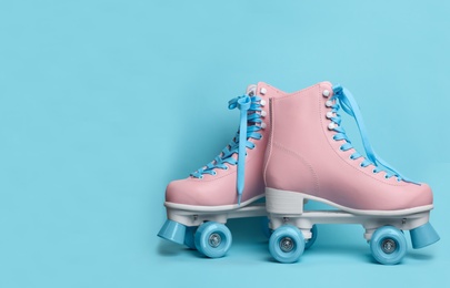 Photo of Pair of stylish quad roller skates on color background. Space for text