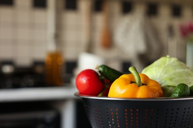 Metal colander with different wet vegetables on table, closeup. Space for text