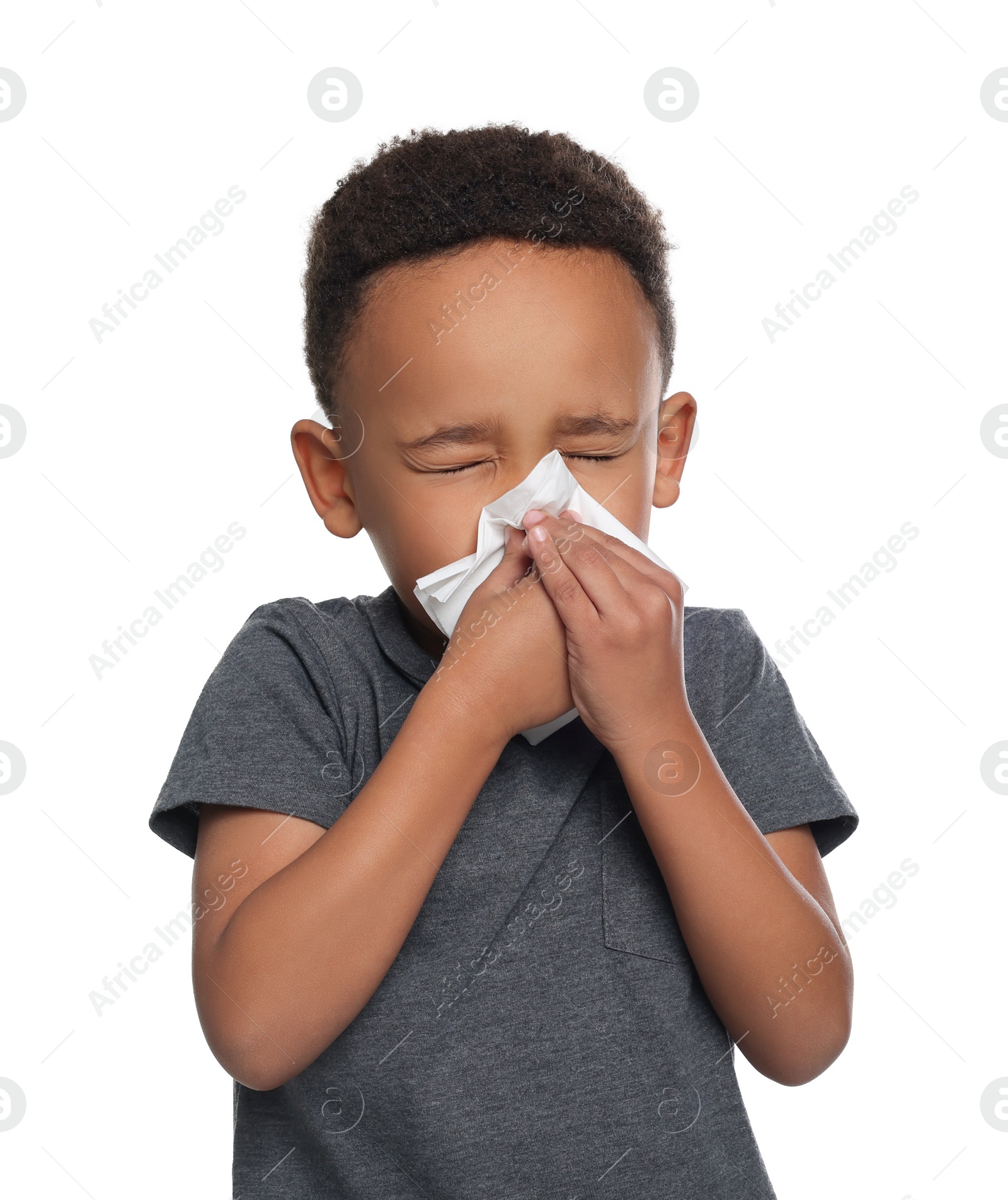 Photo of African-American boy blowing nose in tissue on white background. Cold symptoms