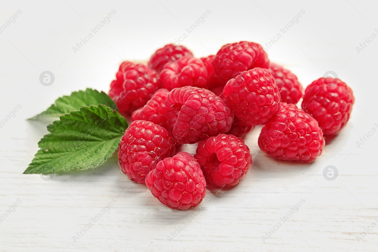 Photo of Ripe aromatic raspberries on wooden table