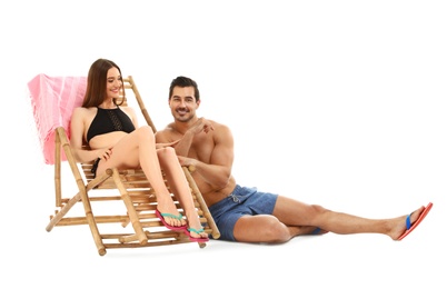 Photo of Young couple with sun lounger on white background. Beach accessories
