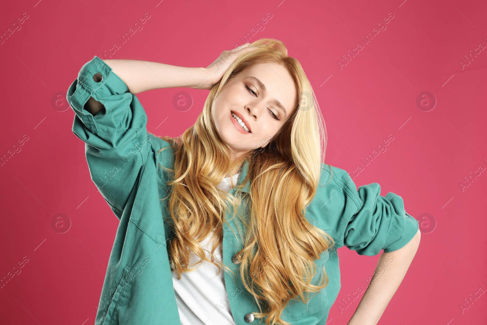 Photo of Portrait of beautiful young woman with dyed long hair on pink background