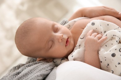 Photo of Mother holding her sleeping baby indoors, closeup