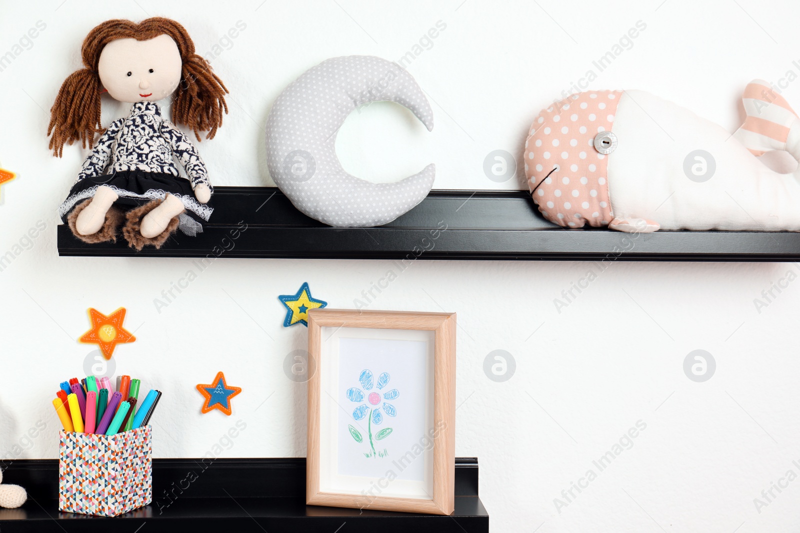 Photo of Cute toys and picture on shelves in child room