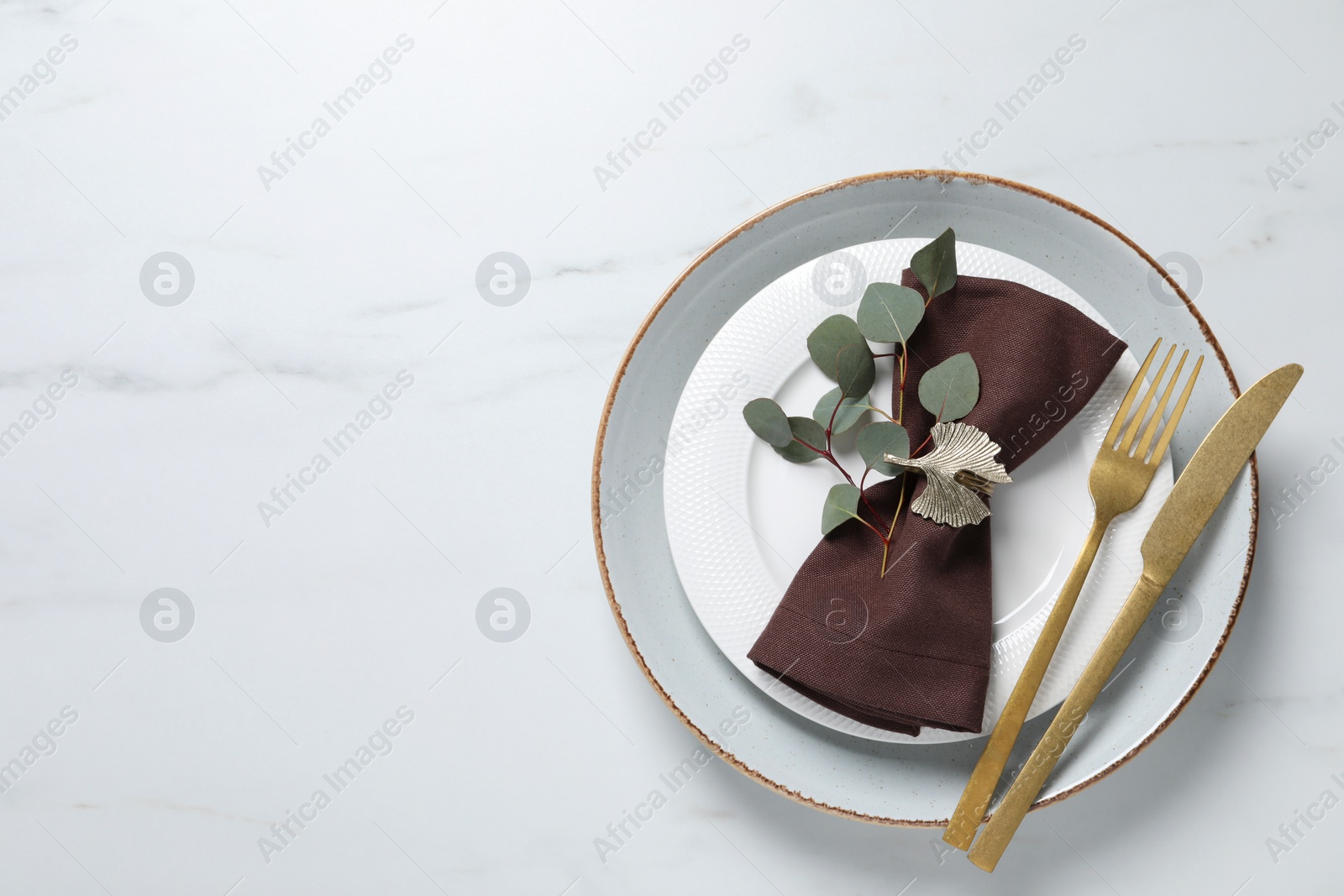 Photo of Stylish table setting with cutlery and eucalyptus leaves, top view. Space for text