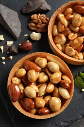 Tartlets with caramelized nuts on black table, top view. Delicious dessert