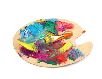Photo of Wooden artist's palette with mixed paints and brush isolated on white