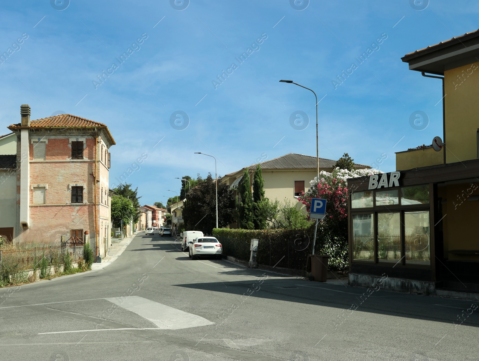 Photo of Beautiful street with buildings, cars and bar on sunny day