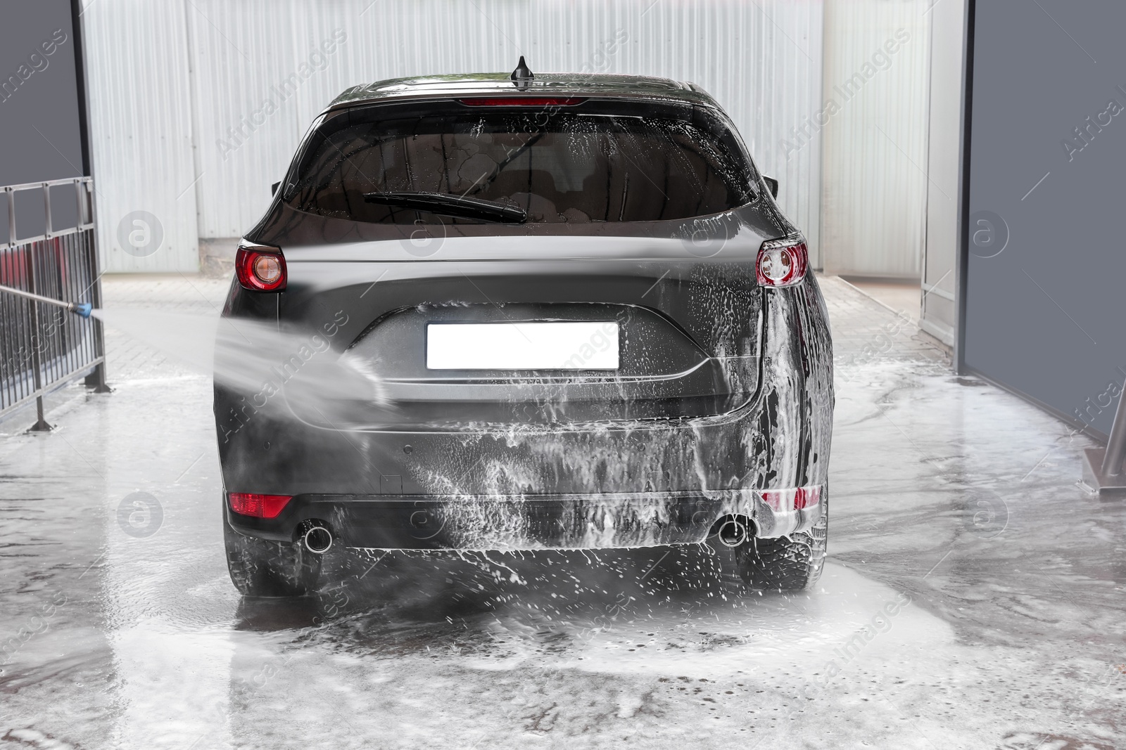 Photo of Washing auto with high pressure water jet at outdoor car wash