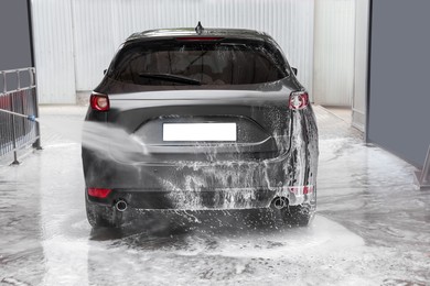 Photo of Washing auto with high pressure water jet at outdoor car wash