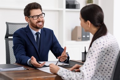 Woman signing document in lawyer's office, selective focus