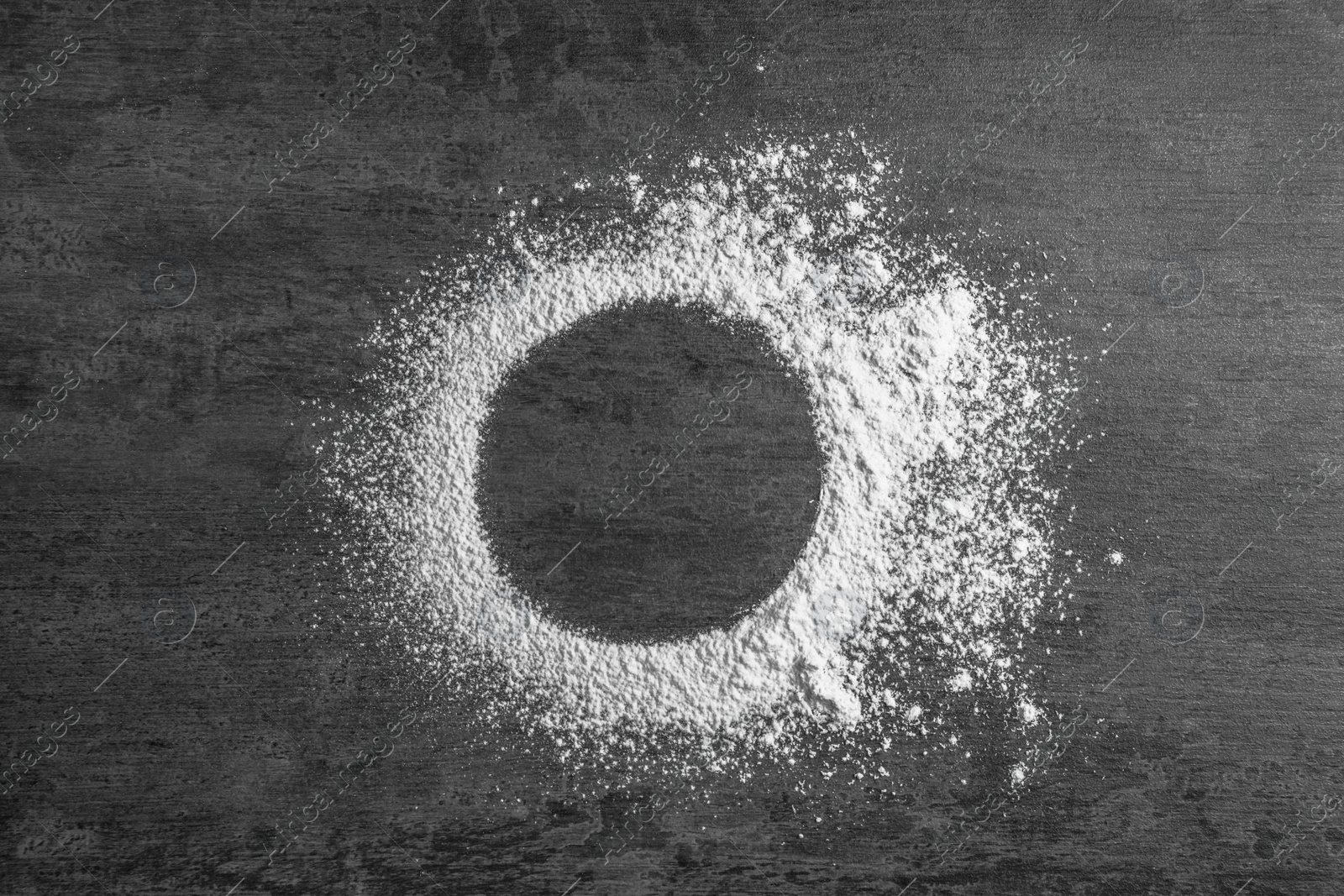 Photo of Round frame made of flour on gray background, top view. Space for text