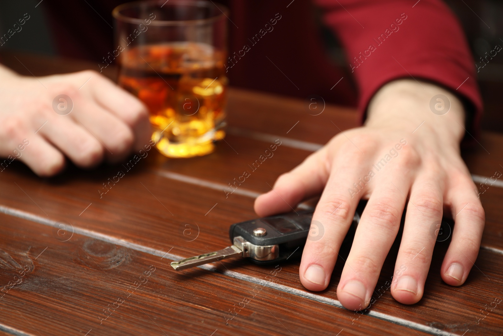 Photo of Drunk man reaching for car keys at table, closeup. Don't drink and drive concept