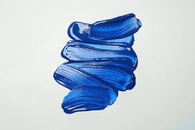Photo of Paint strokes on white background background, top view. Color of the year 2020 (Classic blue)