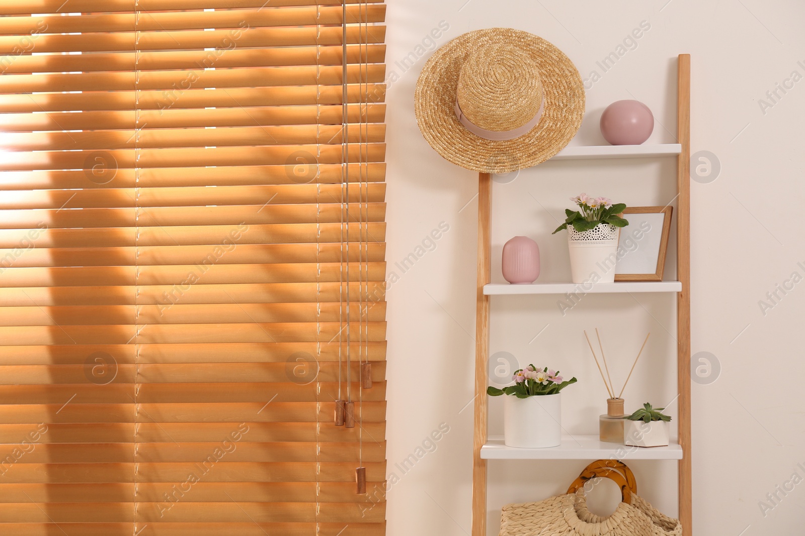 Photo of Stylish room interior with wooden ladder near white wall