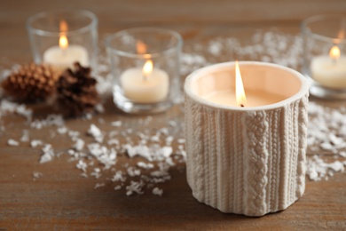 Photo of Candle and Christmas decor on wooden table, space for text