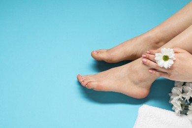 Photo of Woman with neat toenails after pedicure procedure on light blue background, closeup. Space for text