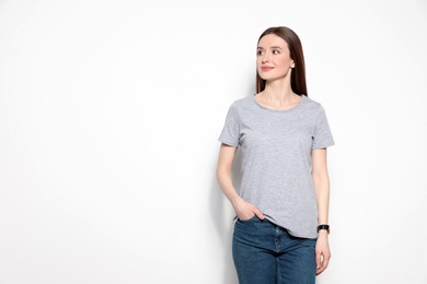 Young woman in t-shirt on light background. Mock up for design