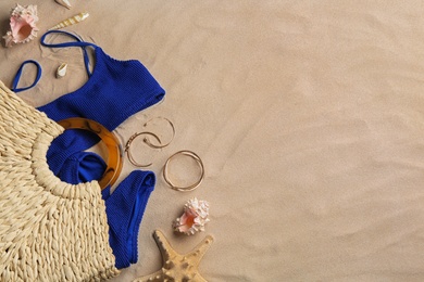 Photo of Different beach accessories on sand, flat lay. Space for text