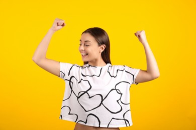 Photo of Strong woman as symbol of girl power on yellow background. 8 March concept