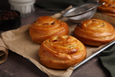 Photo of Delicious rolls on brown textured table, closeup. Sweet buns