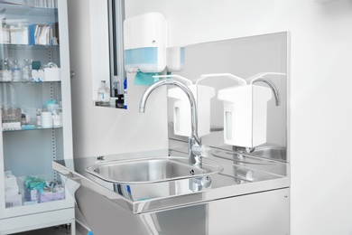 Photo of Sterile steel washbasin in modern surgery room