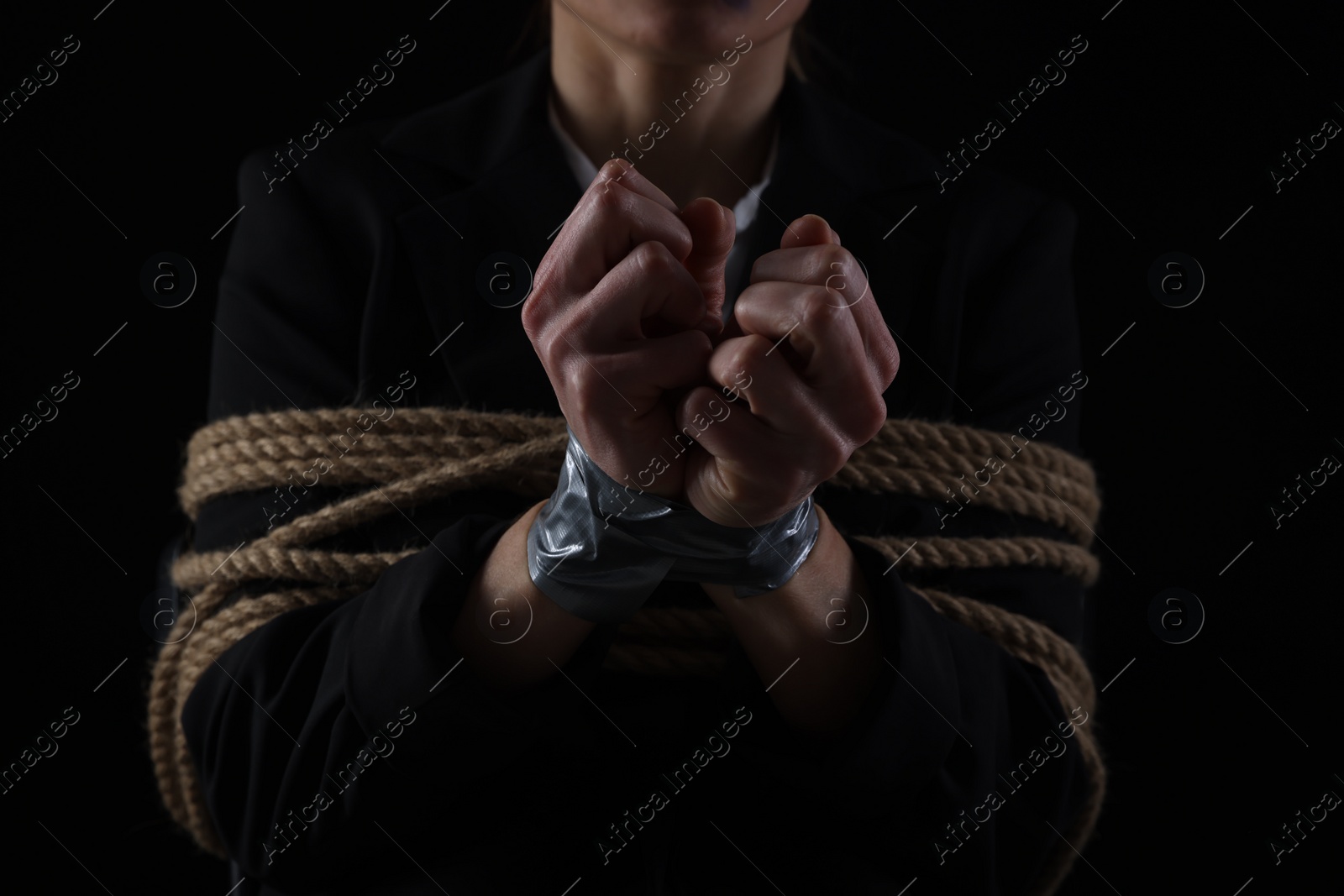 Photo of Woman tied up and taken hostage on dark background, closeup