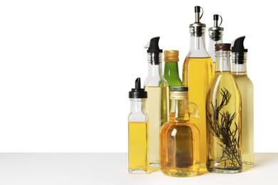 Bottles of different cooking oils on white background, space for text