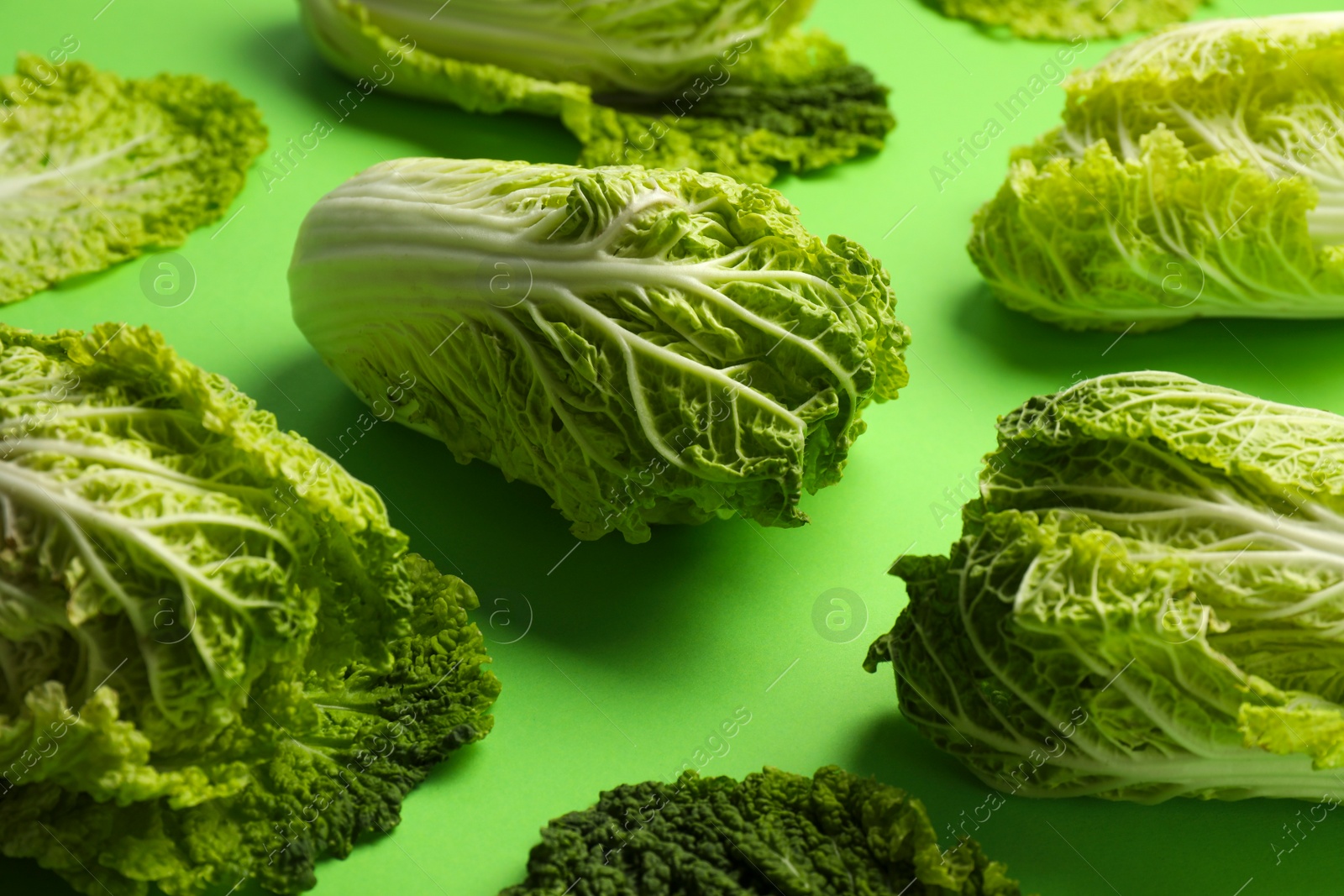 Photo of Fresh ripe Chinese cabbages on light green background