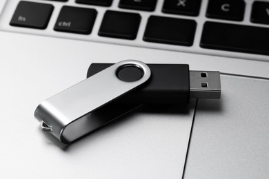 Modern usb flash drive on laptop, closeup