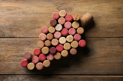 Grape made of wine bottle corks on wooden table, top view