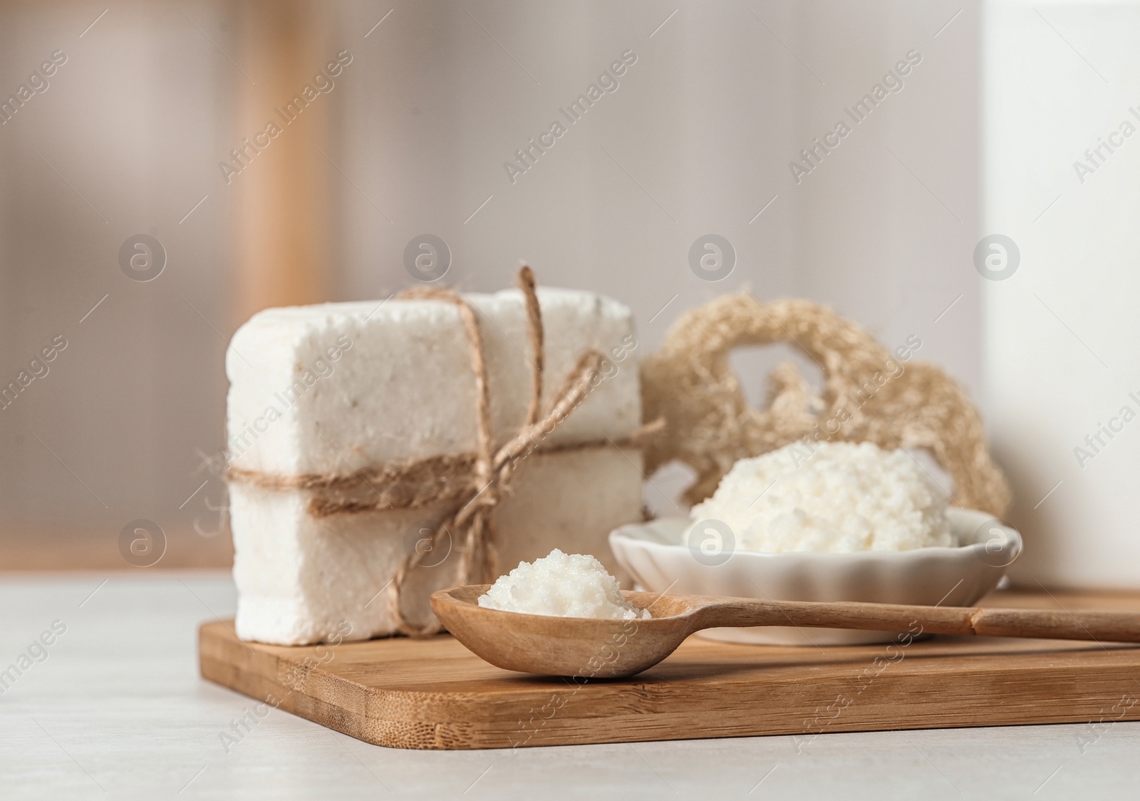 Photo of Board with Shea butter and cosmetic products on table indoors. Space for text