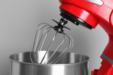 Photo of Modern red stand mixer on light gray background, closeup