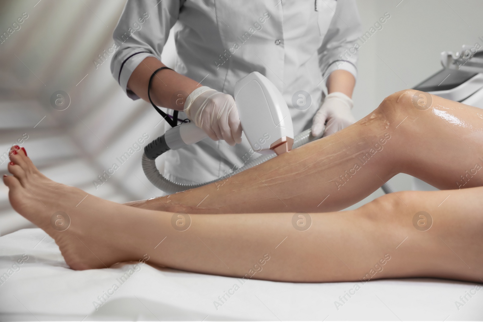 Photo of Woman undergoing laser epilation procedure in beauty salon, closeup