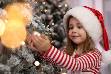 Photo of Cute little child near Christmas tree at home