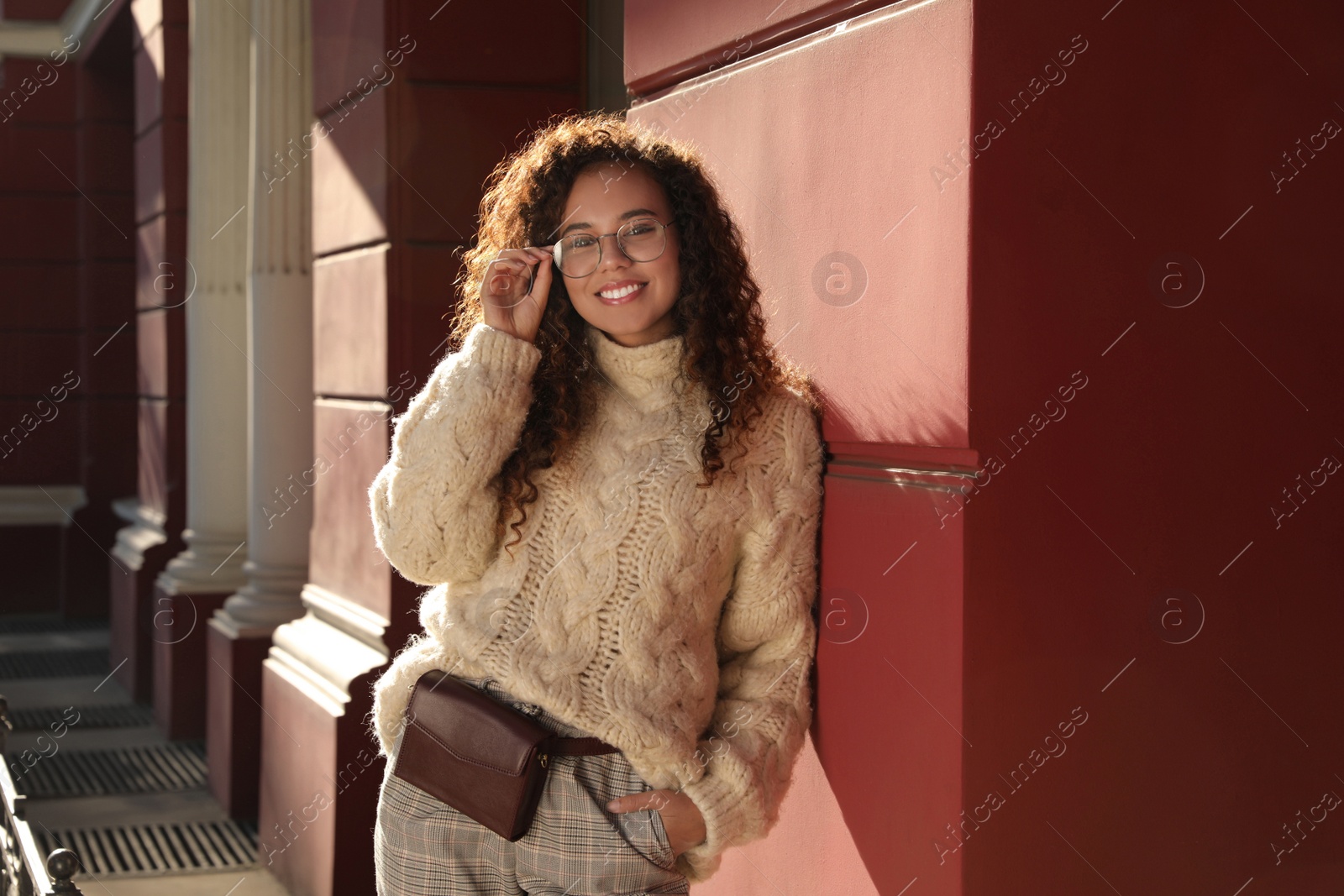 Photo of Beautiful African American woman with stylish waist bag on city street