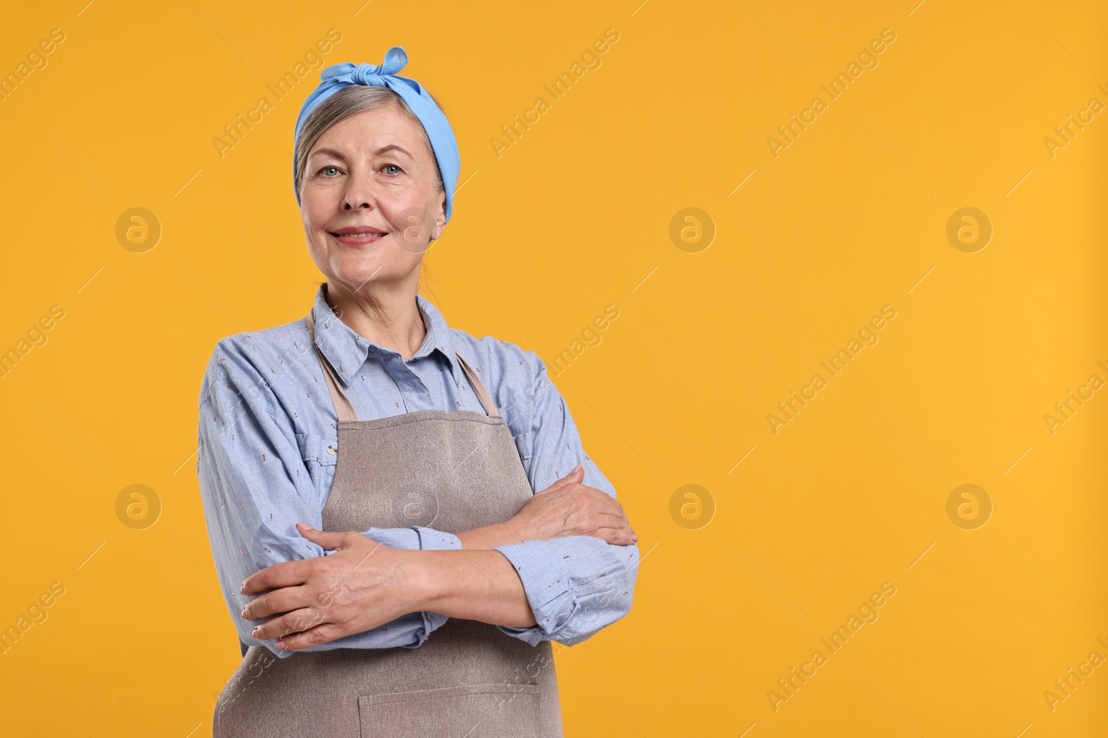 Photo of Happy housewife on orange background, space for text