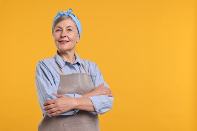 Happy housewife on orange background, space for text