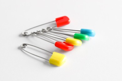 Colorful safety pins on white background, closeup