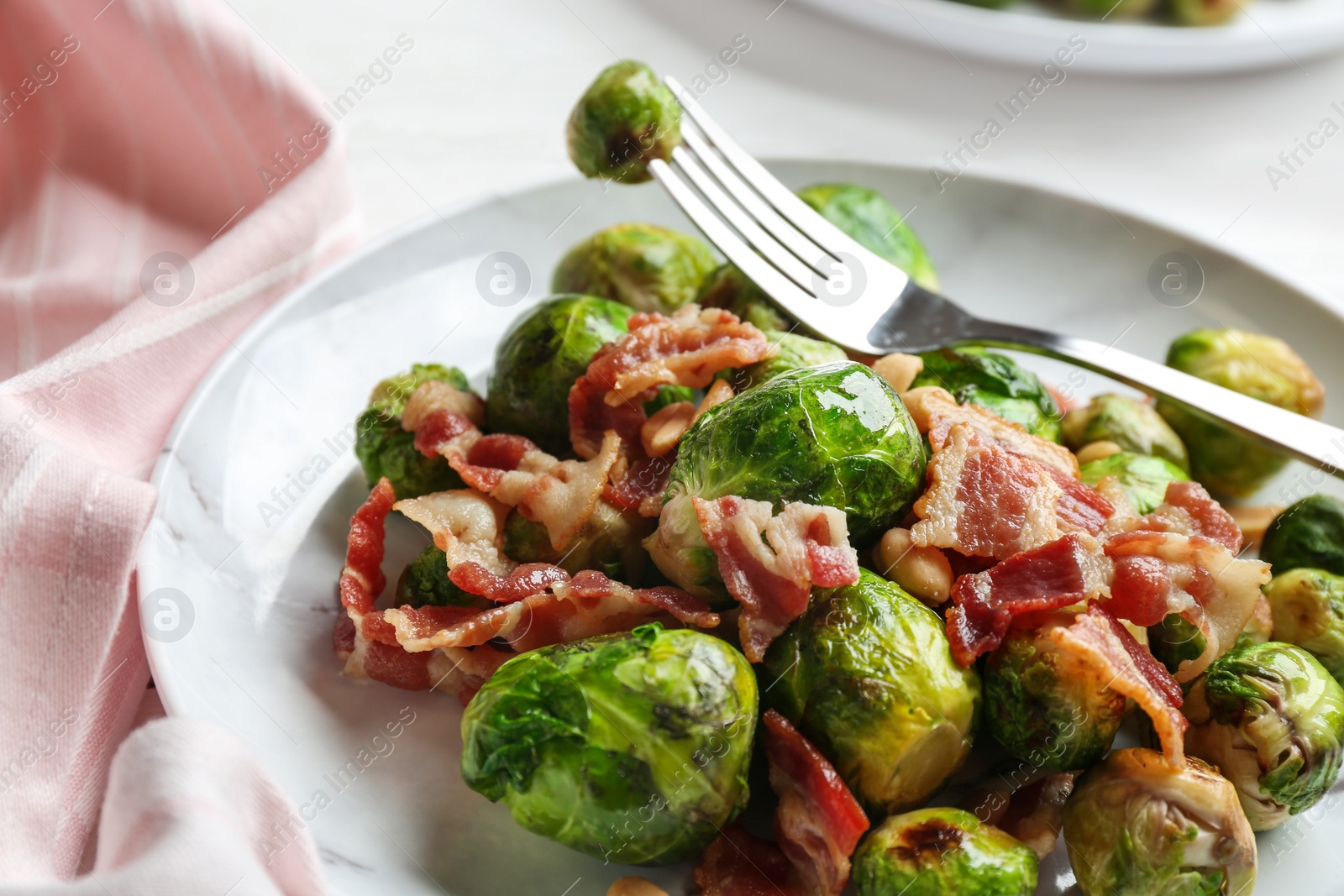 Photo of Delicious Brussels sprouts with bacon on table, closeup