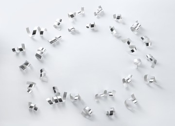 Photo of Frame of shiny serpentine streamers on white background, top view