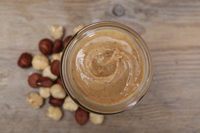 Photo of Tasty hazelnut nut paste in jar on table, top view