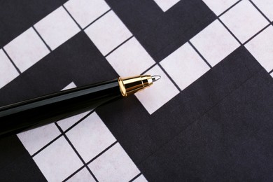 Photo of Pen on blank crossword, top view. Intellectual entertainment