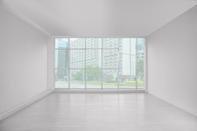 Photo of Empty room with large window and laminated floor