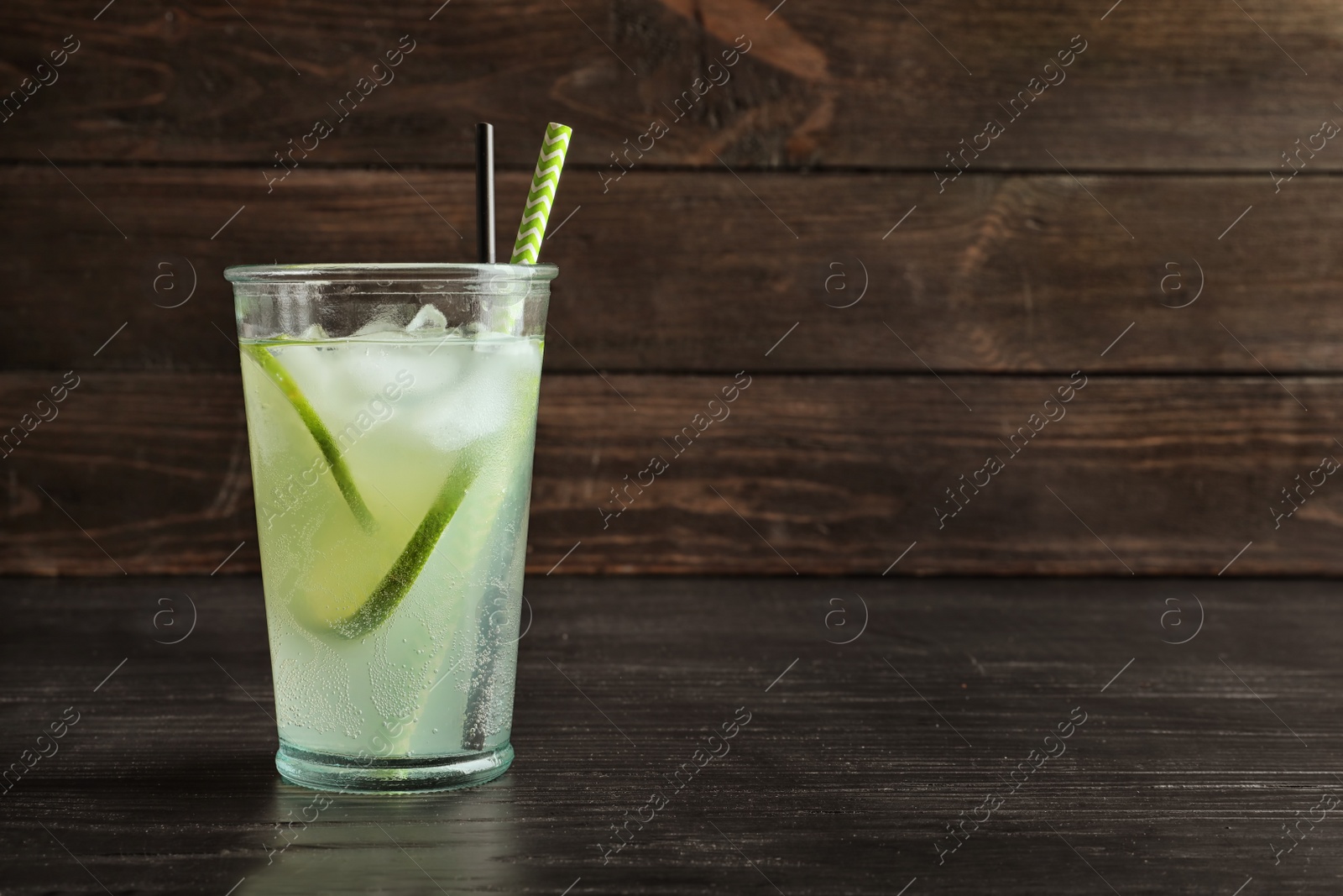 Photo of Natural lemonade with lime in glass on table