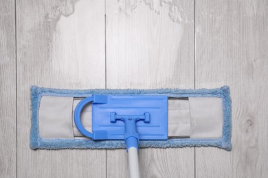 Photo of Cleaning dirty parquet floor with mop indoors, top view