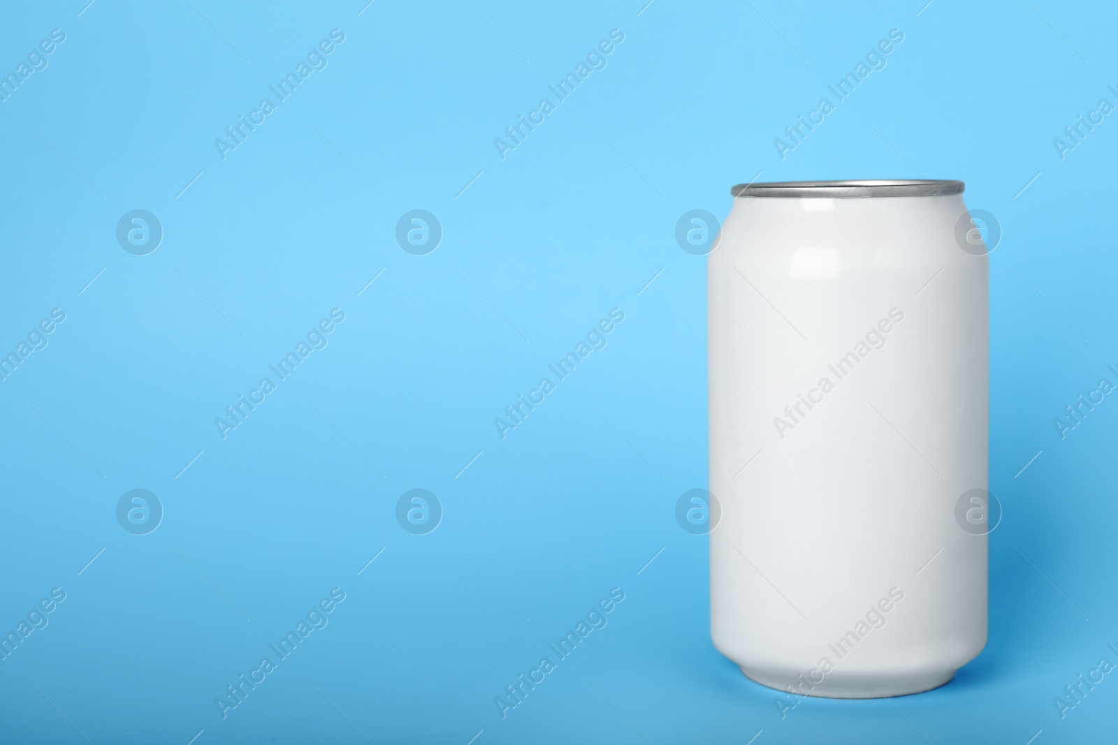 Photo of Can of energy drink on light blue background, space for text