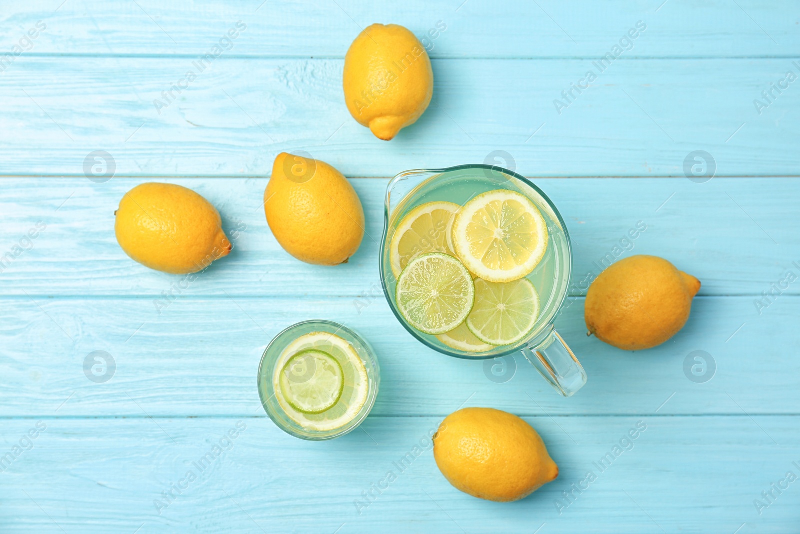 Photo of Flat lay composition with delicious natural lemonade on color wooden background