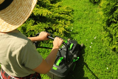 Photo of Woman cutting grass with lawn mower in garden on sunny day