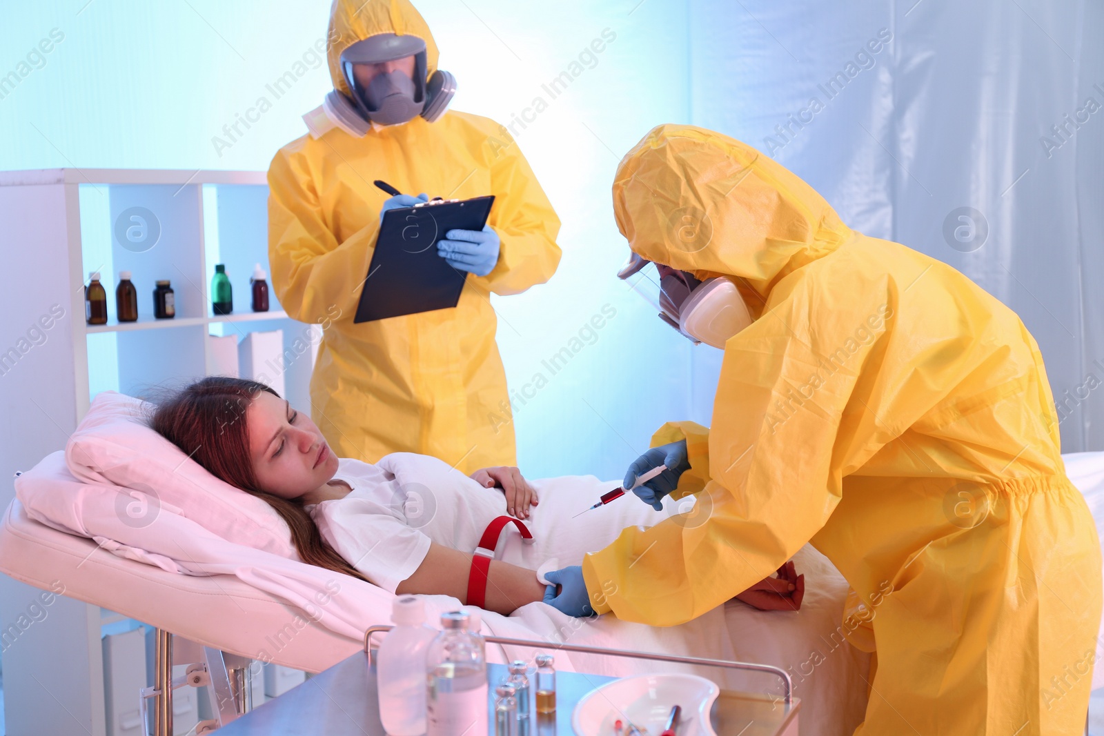 Photo of Professional paramedics injecting vaccine to patient with virus in quarantine ward